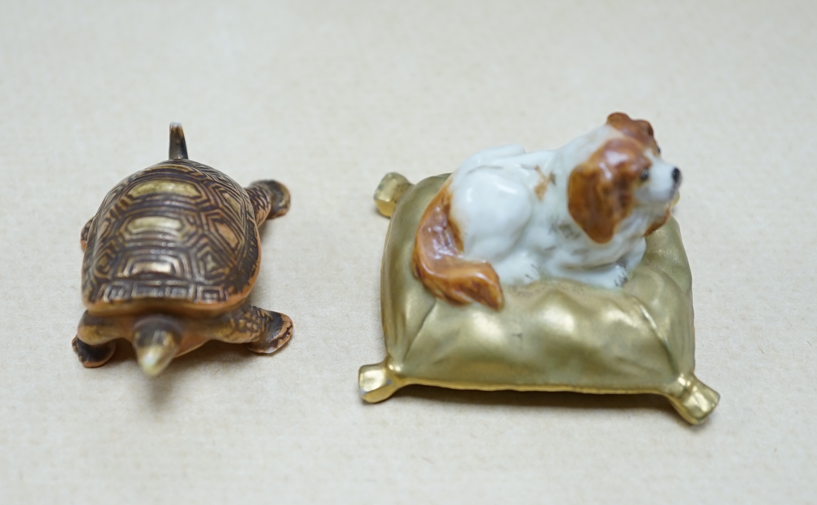 An unusual Royal Worcester miniature King Charles Spaniel sitting on cushion and tortoise, 4cm wide. Condition - fair